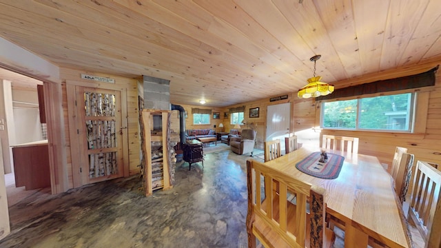 168 W Tucker Ridge Rd, Springfield, ME 04487 - dining area with a wood stove, finished concrete floors, wood ceiling, and wood walls