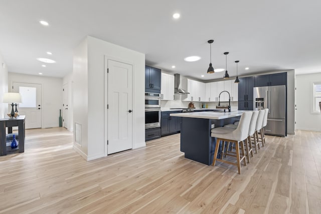 25 Royale Dr, Sidney, ME 04330 - kitchen featuring stainless steel appliances, wall chimney exhaust hood, a breakfast bar, light countertops, and recessed lighting