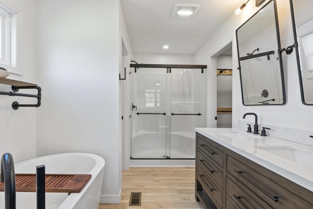 25 Royale Dr, Sidney, ME 04330 - full bathroom featuring wood finished floors, a freestanding tub, a stall shower, double vanity, and recessed lighting