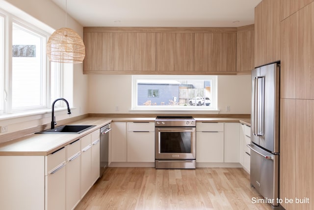 4 Windward Rdg, Biddeford, ME 04005 - kitchen featuring stainless steel appliances, light countertops, light wood-style floors, decorative light fixtures, and white cabinets