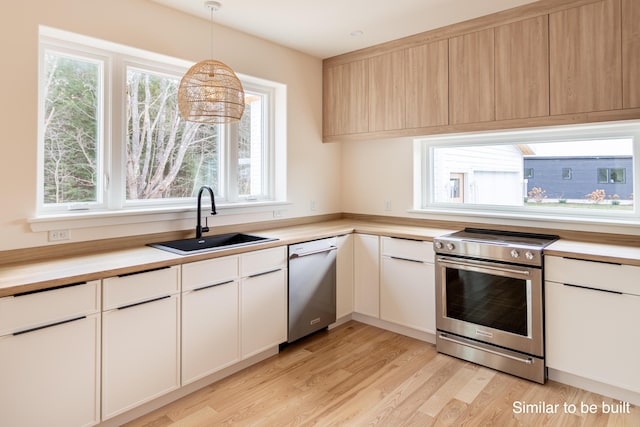 4 Windward Rdg, Biddeford, ME 04005 - kitchen with appliances with stainless steel finishes, light wood-style flooring, pendant lighting, and white cabinetry