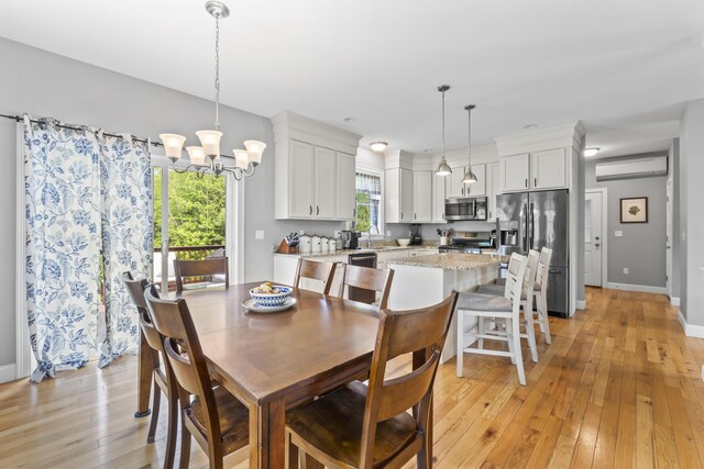 54 Tree Farm Rd, Brunswick, ME 04011 - dining room with a wall mounted air conditioner, light wood finished floors, a chandelier, and baseboards