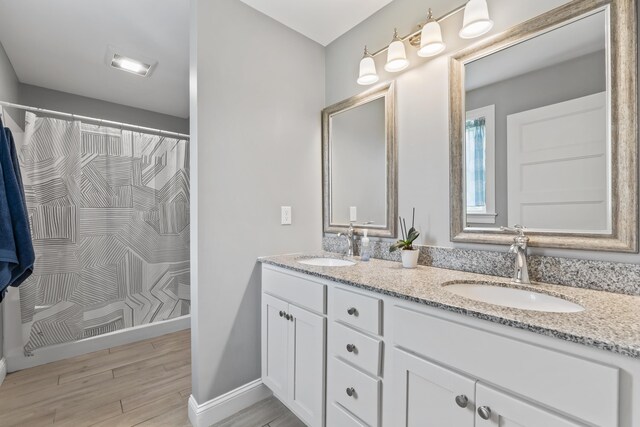 54 Tree Farm Rd, Brunswick, ME 04011 - full bathroom with double vanity, a shower with shower curtain, wood finished floors, and baseboards
