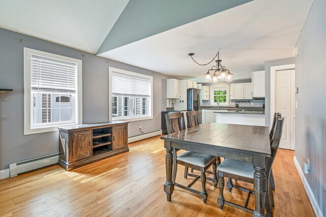 38 Shadagee Rd, Saco, ME 04072 - dining room with a baseboard heating unit, light wood-style flooring, a chandelier, baseboards, and vaulted ceiling
