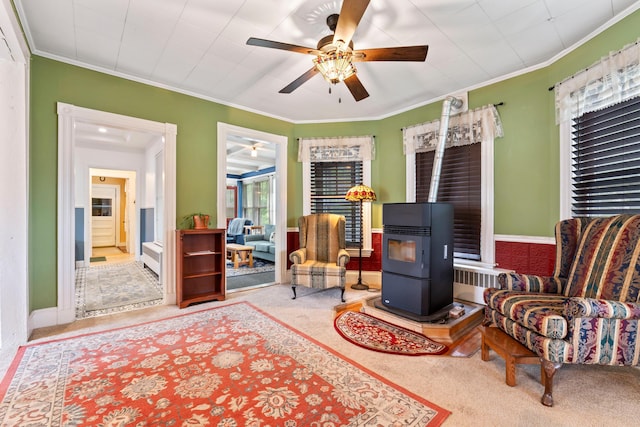 10 Hollingsworth St, Winslow, ME 04901 - living area with a wood stove, carpet floors, a ceiling fan, and crown molding