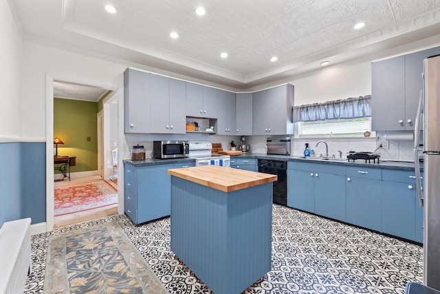 10 Hollingsworth St, Winslow, ME 04901 - kitchen with stainless steel appliances, wooden counters, recessed lighting, a tray ceiling, and blue cabinetry