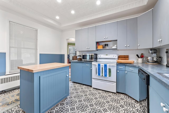 10 Hollingsworth St, Winslow, ME 04901 - kitchen with white electric stove, butcher block counters, radiator, stainless steel microwave, and recessed lighting