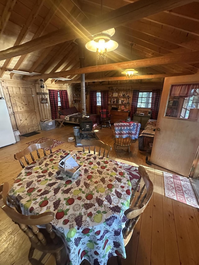 30 Cove View Ln Unit T3, Indian Purchase Twp, ME 04462 - dining area with a wood stove, wood-type flooring, wooden walls, and wooden ceiling