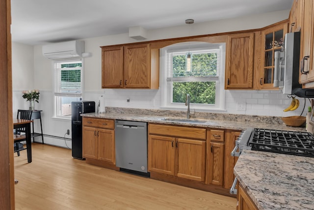 6 Goff Ave, Lewiston, ME 04240 - kitchen featuring appliances with stainless steel finishes, an AC wall unit, a sink, light stone counters, and brown cabinetry