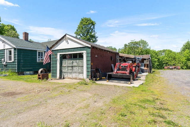 54 Middle Rd, Augusta, ME 04330 - view of property exterior with a chimney, dirt driveway, an outdoor structure, a garage, and roof with shingles
