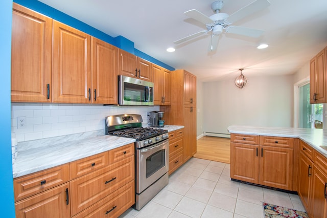 12 Hixon Hill Dr, Woolwich, ME 04579 - kitchen featuring appliances with stainless steel finishes, baseboard heating, tasteful backsplash, light tile patterned floors, and a ceiling fan