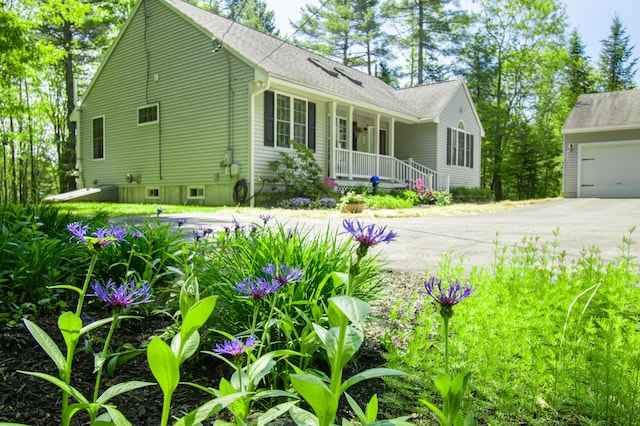 12 Hixon Hill Dr, Woolwich, ME 04579 - view of front of property featuring a porch, a garage, driveway, and roof with shingles