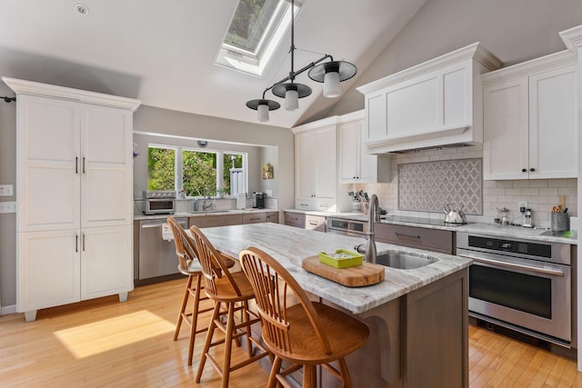 3 Blueberry Rd Unit 3, Yarmouth, ME 04096 - kitchen featuring appliances with stainless steel finishes, a skylight, a sink, lofted ceiling, and tasteful backsplash