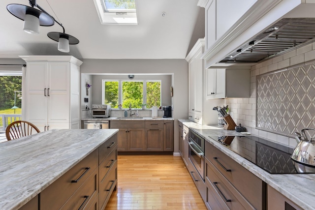 3 Blueberry Rd Unit 3, Yarmouth, ME 04096 - kitchen featuring custom range hood, appliances with stainless steel finishes, a sink, a skylight, and light wood finished floors