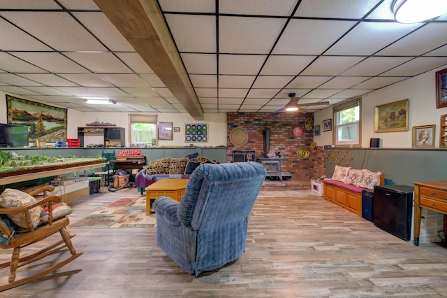 40 Sanborn St, Gorham, ME 04038 - living room with a wood stove, light wood-type flooring, a paneled ceiling, and wainscoting