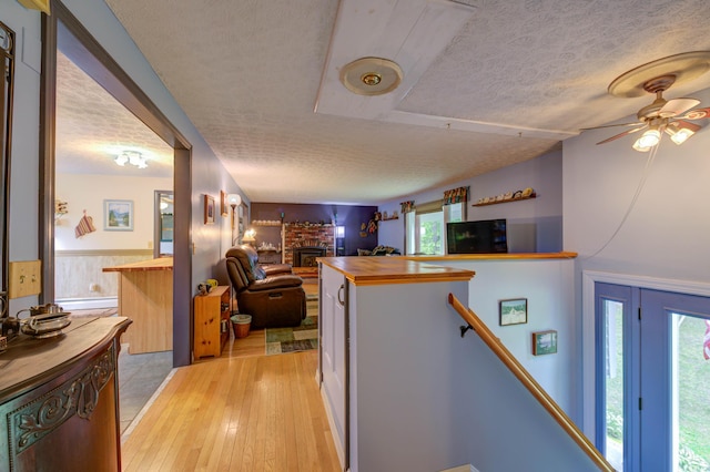 40 Sanborn St, Gorham, ME 04038 - kitchen featuring wood counters, a brick fireplace, a textured ceiling, open floor plan, and light wood-style floors