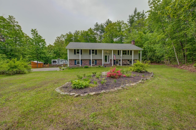 40 Sanborn St, Gorham, ME 04038 - raised ranch featuring covered porch, a chimney, a front lawn, brick siding, and a wooded view