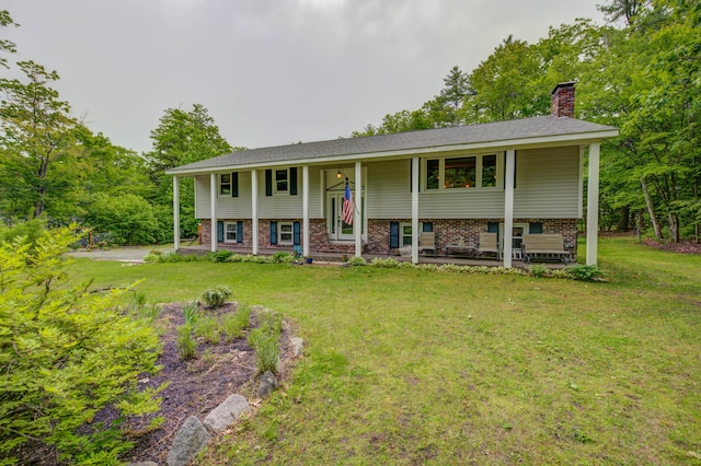 40 Sanborn St, Gorham, ME 04038 - split foyer home featuring a chimney, a front lawn, brick siding, and covered porch