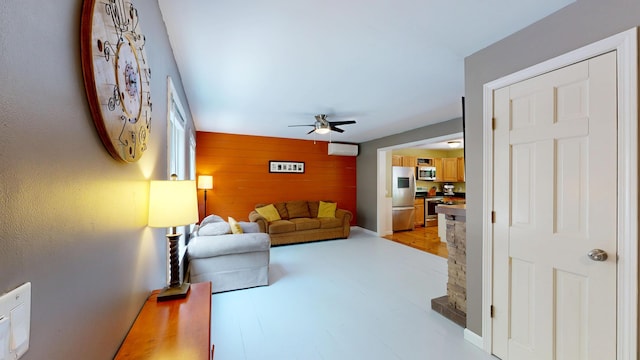 471 Owls Nest Rd, Shapleigh, ME 04076 - living room featuring ceiling fan, wood walls, and an accent wall