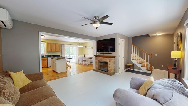 471 Owls Nest Rd, Shapleigh, ME 04076 - living area with a ceiling fan, stairway, a wall mounted air conditioner, and light wood-style flooring