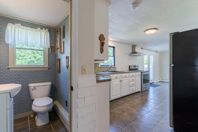 110 Elm St, North Berwick, ME 03906 - kitchen with appliances with stainless steel finishes, wall chimney exhaust hood, a baseboard radiator, wallpapered walls, and a sink