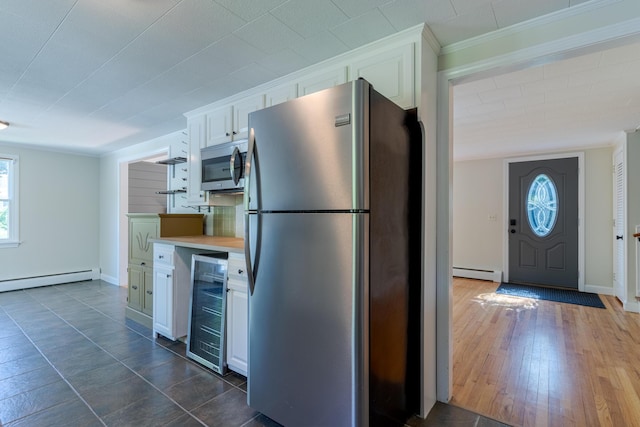 110 Elm St, North Berwick, ME 03906 - kitchen with stainless steel appliances, wine cooler, a baseboard radiator, white cabinets, and crown molding