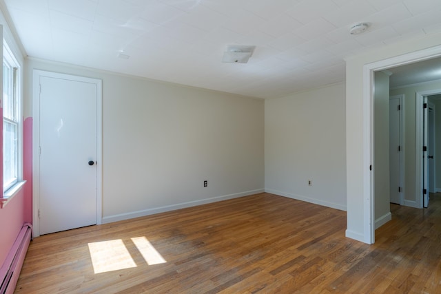110 Elm St, North Berwick, ME 03906 - empty room with a baseboard radiator, crown molding, plenty of natural light, wood finished floors, and baseboards