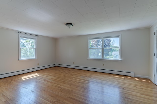 110 Elm St, North Berwick, ME 03906 - empty room with light wood-type flooring, crown molding, a baseboard heating unit, and baseboards
