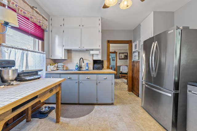 94 Union St, Bath, ME 04530 - kitchen featuring stainless steel appliances, a sink, white cabinetry, tasteful backsplash, and light countertops