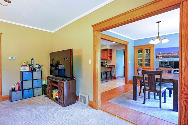 24 Western Ave, Auburn, ME 04210 - dining space with a chandelier, crown molding, baseboards, and wood finished floors