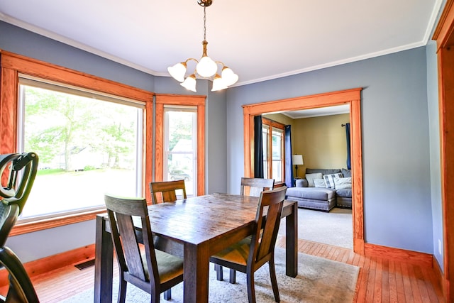24 Western Ave, Auburn, ME 04210 - dining room featuring a chandelier, plenty of natural light, ornamental molding, light wood finished floors, and baseboards