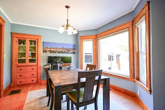 24 Western Ave, Auburn, ME 04210 - dining room with light wood-style floors, a chandelier, ornamental molding, and baseboards