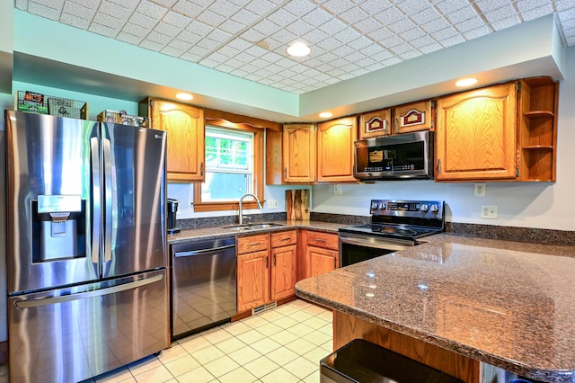 24 Western Ave, Auburn, ME 04210 - kitchen featuring stainless steel appliances, a sink, a peninsula, dark stone counters, and brown cabinets