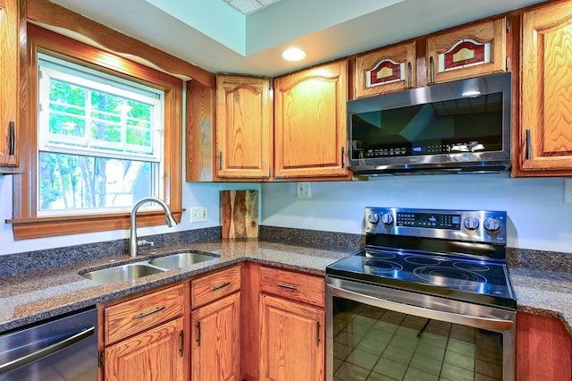 24 Western Ave, Auburn, ME 04210 - kitchen featuring stainless steel appliances, a sink, dark stone counters, brown cabinetry, and recessed lighting