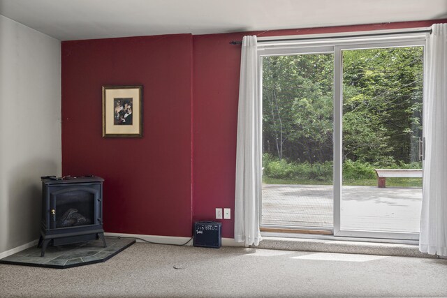 27 Russell Ln, Damariscotta, ME 04543 - unfurnished living room featuring a wood stove and carpet