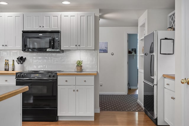 27 Russell Ln, Damariscotta, ME 04543 - kitchen with black appliances, light wood-style floors, white cabinets, tasteful backsplash, and recessed lighting