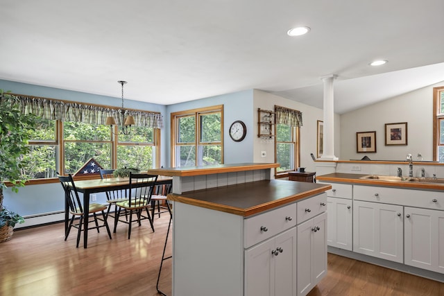 27 Russell Ln, Damariscotta, ME 04543 - kitchen with ornate columns, dark countertops, wood finished floors, white cabinets, and recessed lighting