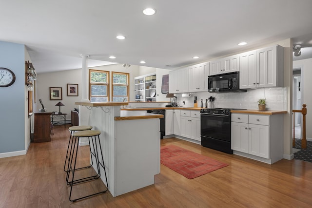 27 Russell Ln, Damariscotta, ME 04543 - kitchen featuring black appliances, wooden counters, a peninsula, a breakfast bar area, and light wood-style floors