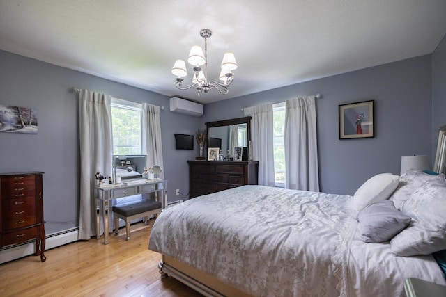 76 Punkintown Rd, Eliot, ME 03903 - bedroom with an AC wall unit, a chandelier, and light wood-type flooring