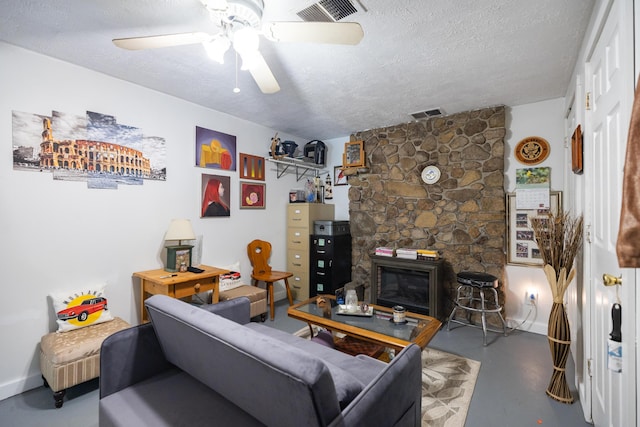 76 Punkintown Rd, Eliot, ME 03903 - living room with finished concrete floors, a ceiling fan, a textured ceiling, and a fireplace