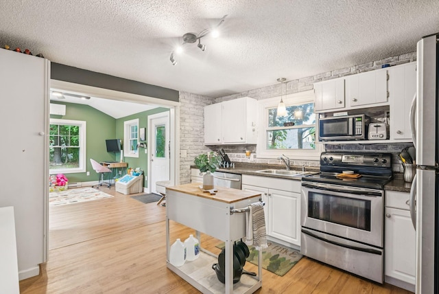 11 Meadow Ln, Portland, ME 04103 - kitchen with stainless steel appliances, a sink, white cabinetry, light wood-type flooring, and a textured ceiling