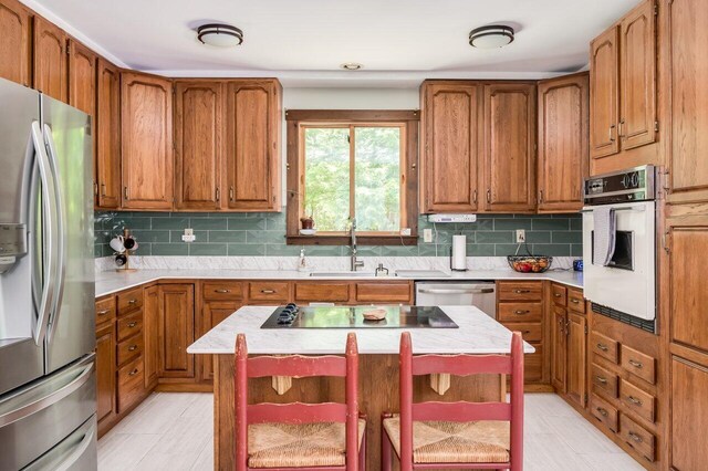 44 Pine Meadow Ct, North Berwick, ME 03906 - kitchen featuring appliances with stainless steel finishes, a sink, light countertops, and brown cabinetry