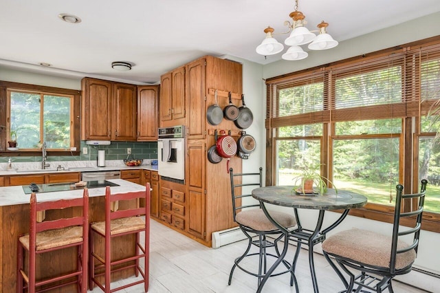 44 Pine Meadow Ct, North Berwick, ME 03906 - kitchen featuring oven, a sink, light countertops, a chandelier, and brown cabinets