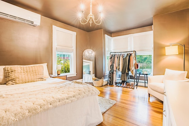 24 High St, Livermore Falls, ME 04254 - bedroom with a wall mounted air conditioner, light wood-style flooring, a chandelier, and a baseboard radiator