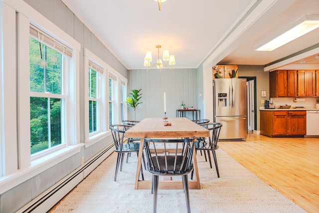 24 High St, Livermore Falls, ME 04254 - dining area with a baseboard heating unit, healthy amount of natural light, crown molding, light wood finished floors, and a chandelier