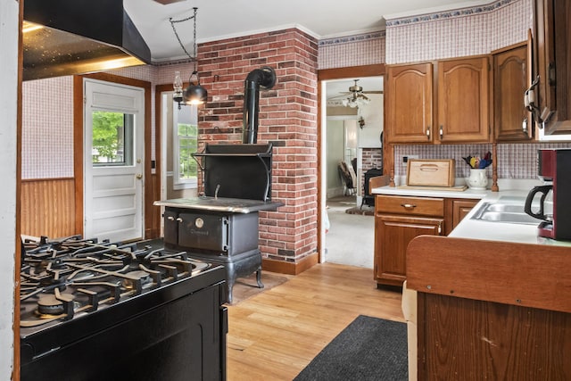 785 W Main St, Waldoboro, ME 04572 - kitchen with a wood stove, a ceiling fan, light wood-type flooring, wallpapered walls, and black gas range