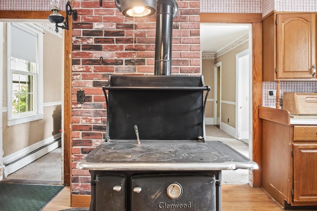 785 W Main St, Waldoboro, ME 04572 - detailed view of baseboard heating, a wood stove, wood finished floors, and ornamental molding