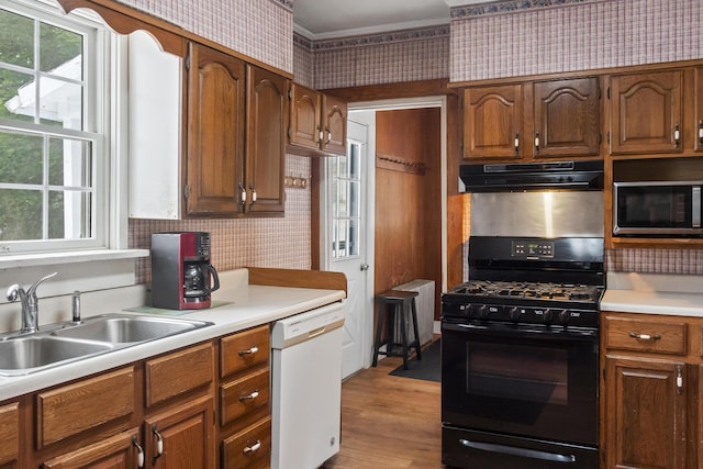785 W Main St, Waldoboro, ME 04572 - kitchen with black gas range, white dishwasher, stainless steel microwave, under cabinet range hood, and wallpapered walls
