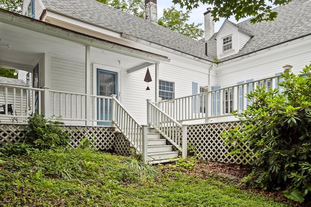 785 W Main St, Waldoboro, ME 04572 - rear view of house featuring a chimney, a porch, roof with shingles, and stairway
