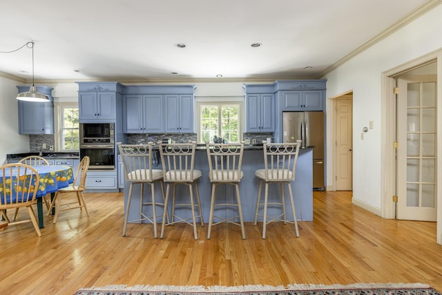36 Acorn Ln, South Portland, ME 04106 - kitchen featuring stainless steel appliances, blue cabinets, crown molding, a breakfast bar area, and tasteful backsplash